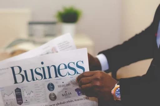 Person reading a news paper exploring 2025 business trends